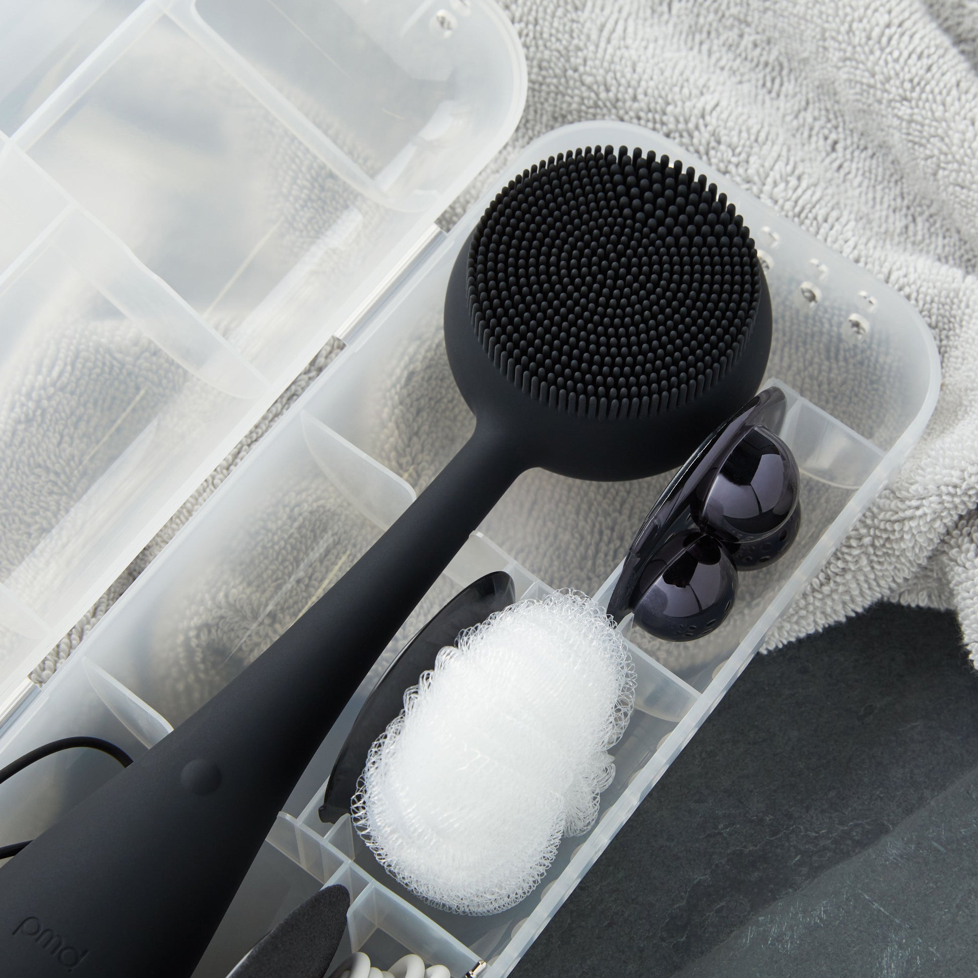 4003-Case?PMD Clean Body Case on towel with black PMD Clean Body and accessories inside