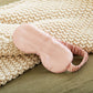 5008-SMROSE?Closeup of silversilk sleep mask in rose next to woven blanket